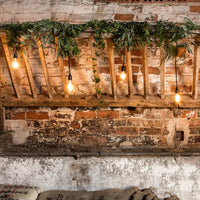 Koppelbare Ingenious Connect Beleuchtung mit warmweißen Hängelampen und grüner Girlande