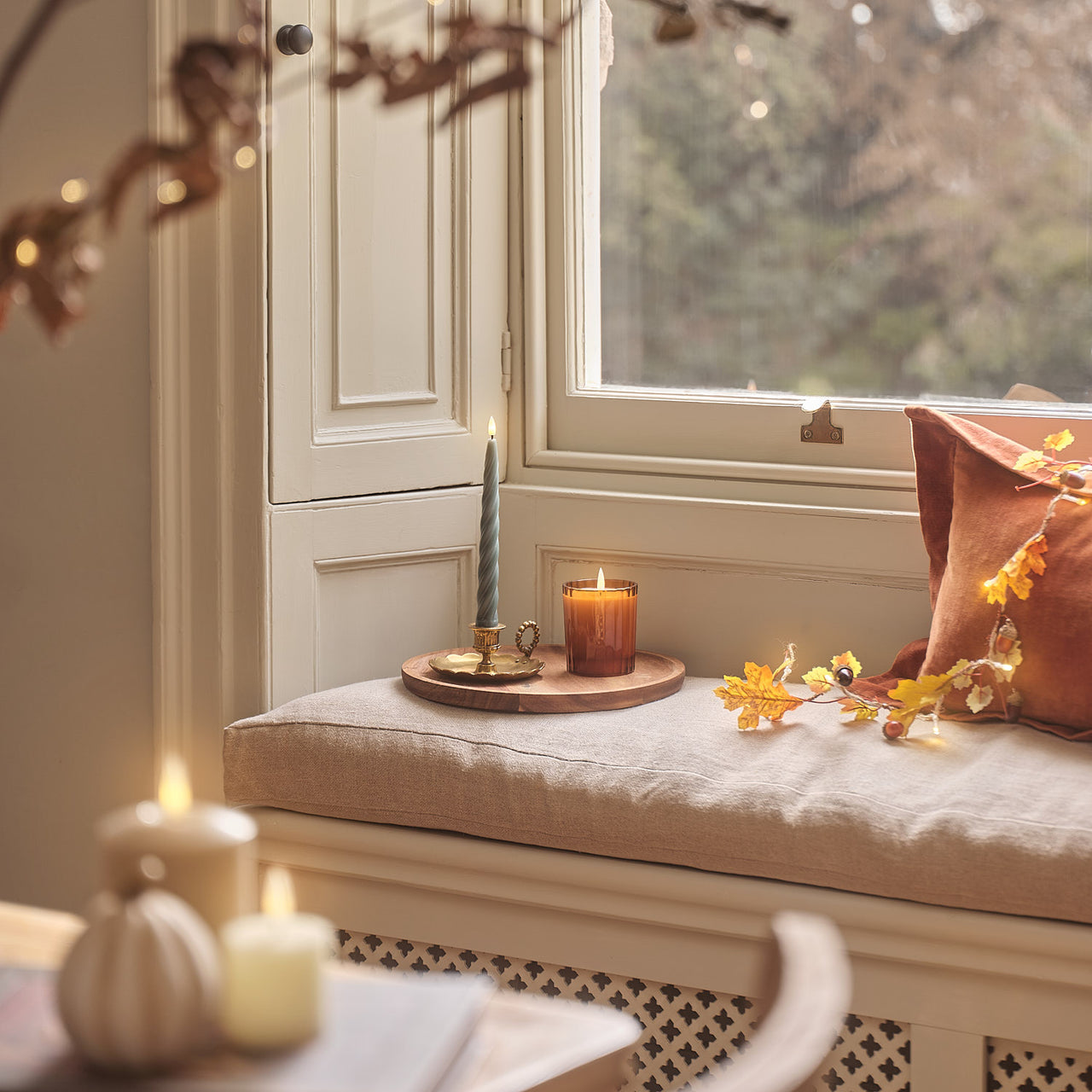 TruGlow® LED-Kerze im geriffelten Glas mit Fernbedienung in Orange auf Fensterbank