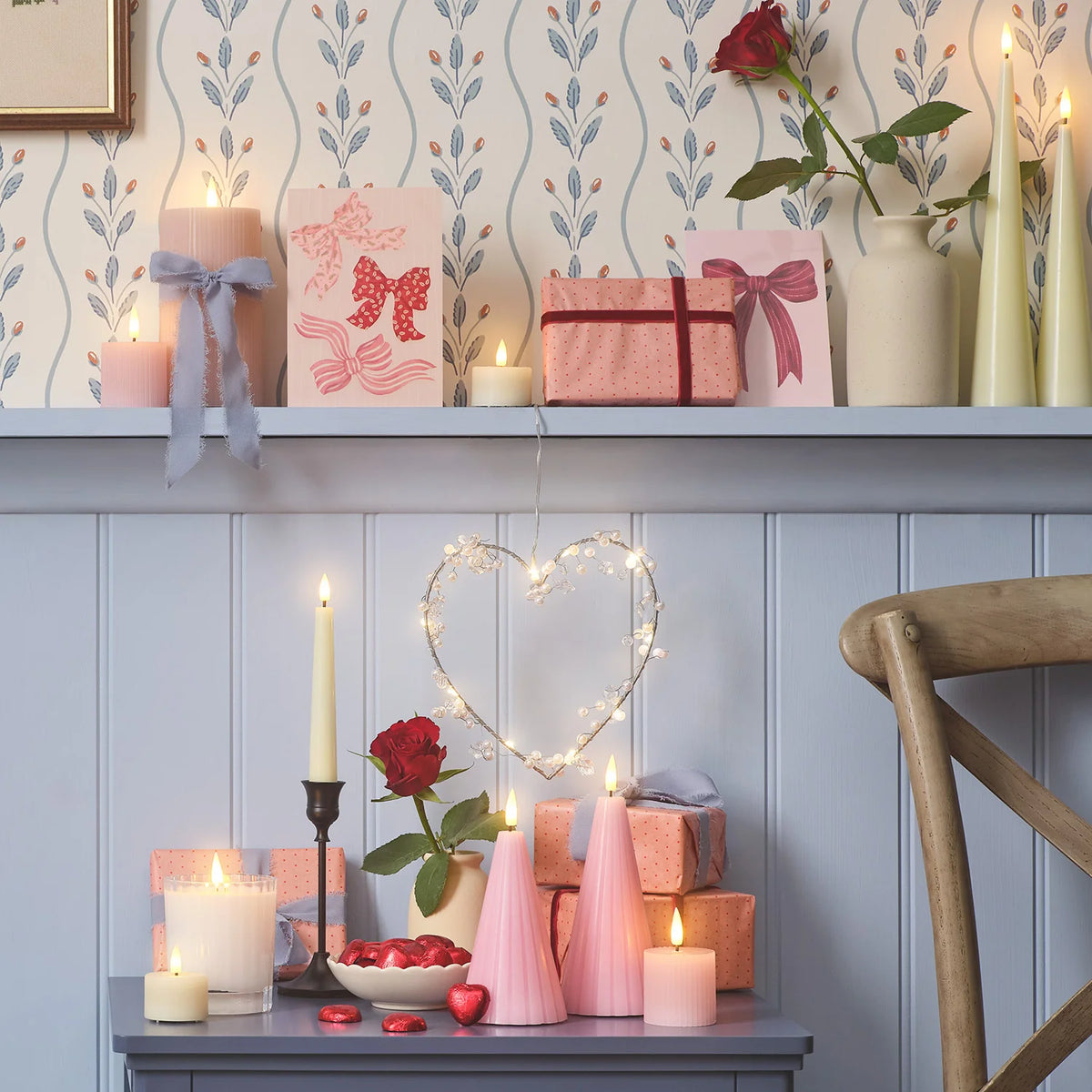 Rosa LED-Kegelkerzen mit Fernbedienung auf Tisch mit Valentinstagsdeko