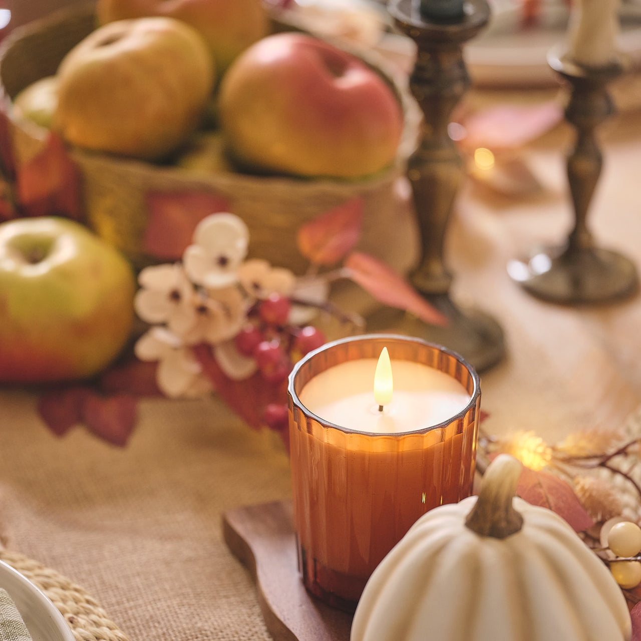 TruGlow® LED-Kerze im geriffelten Glas mit Fernbedienung in Orange auf Tisch mit Obstkorb