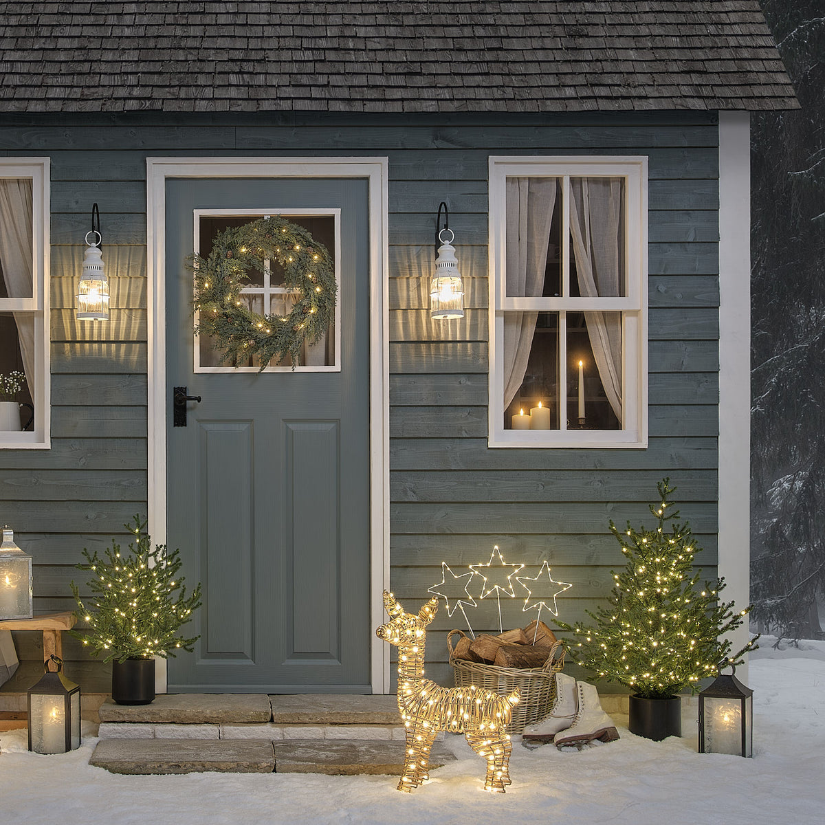 Beleuchtete LED-Stern-Gartenstecker dekorieren den Eingangsbereich eines Hauses im Schnee