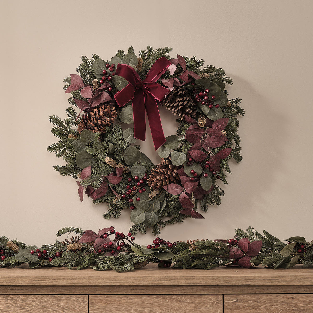 Weihnachtskranz mit roten und grünen Blättern, Tannenzapfen und roter Schleife ohne Beleuchtung