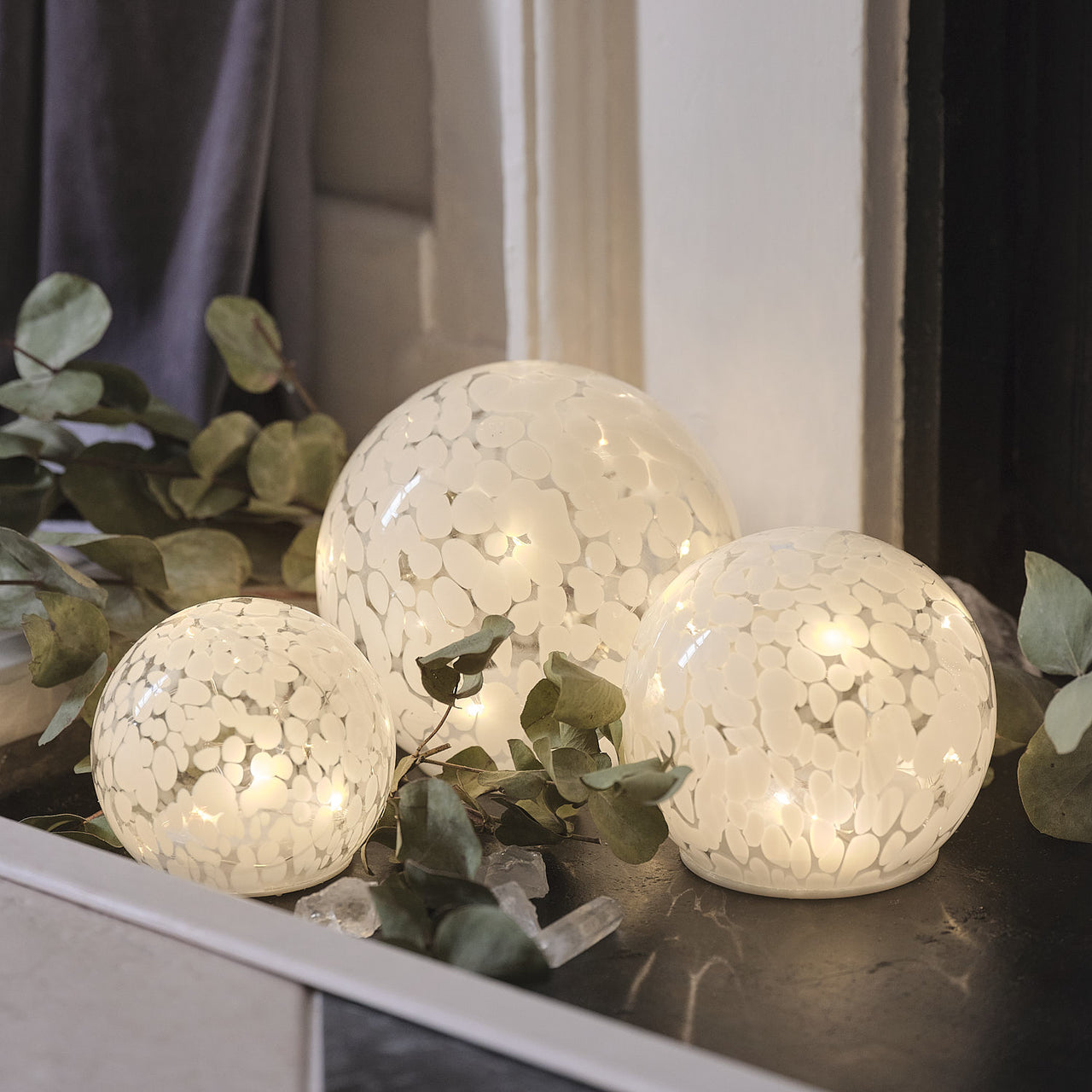 10 cm LED-Glaskugel mit Timer aus Konfettiglas im Set beleuchtet auf Fensterbank