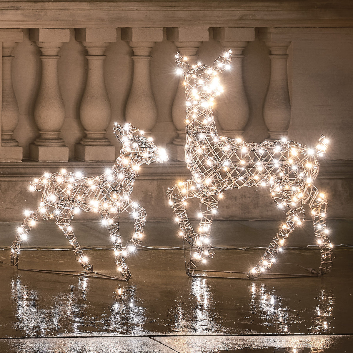 LED-Rentier Hirschkuh und Rehkitz mit kaltweißen LEDs leuchtend vor Steinbalustrade