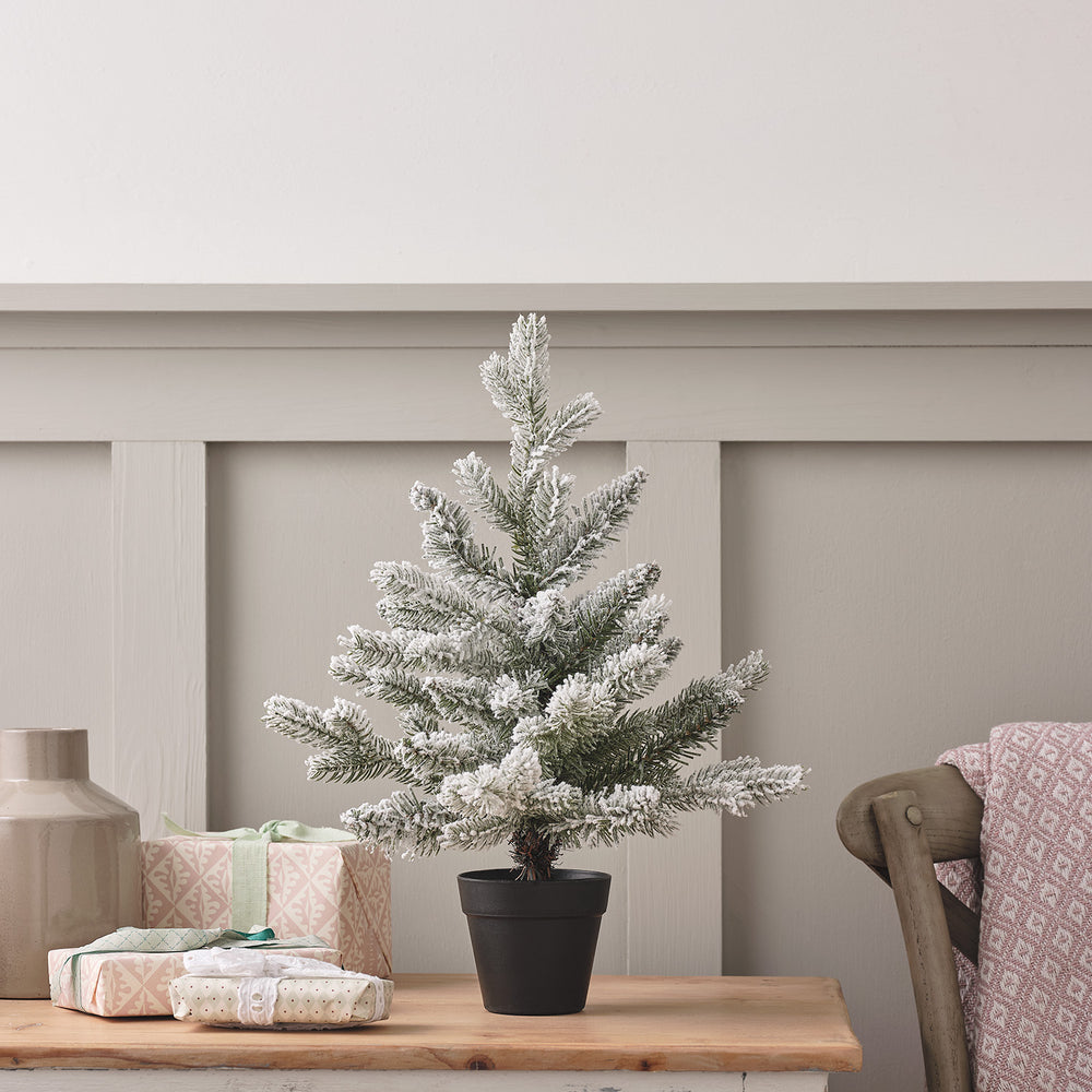 45cm kleiner künstlicher Weihnachtsbaum mit Schneeeffekt in schwarzem Topf auf Holztisch neben Geschenken