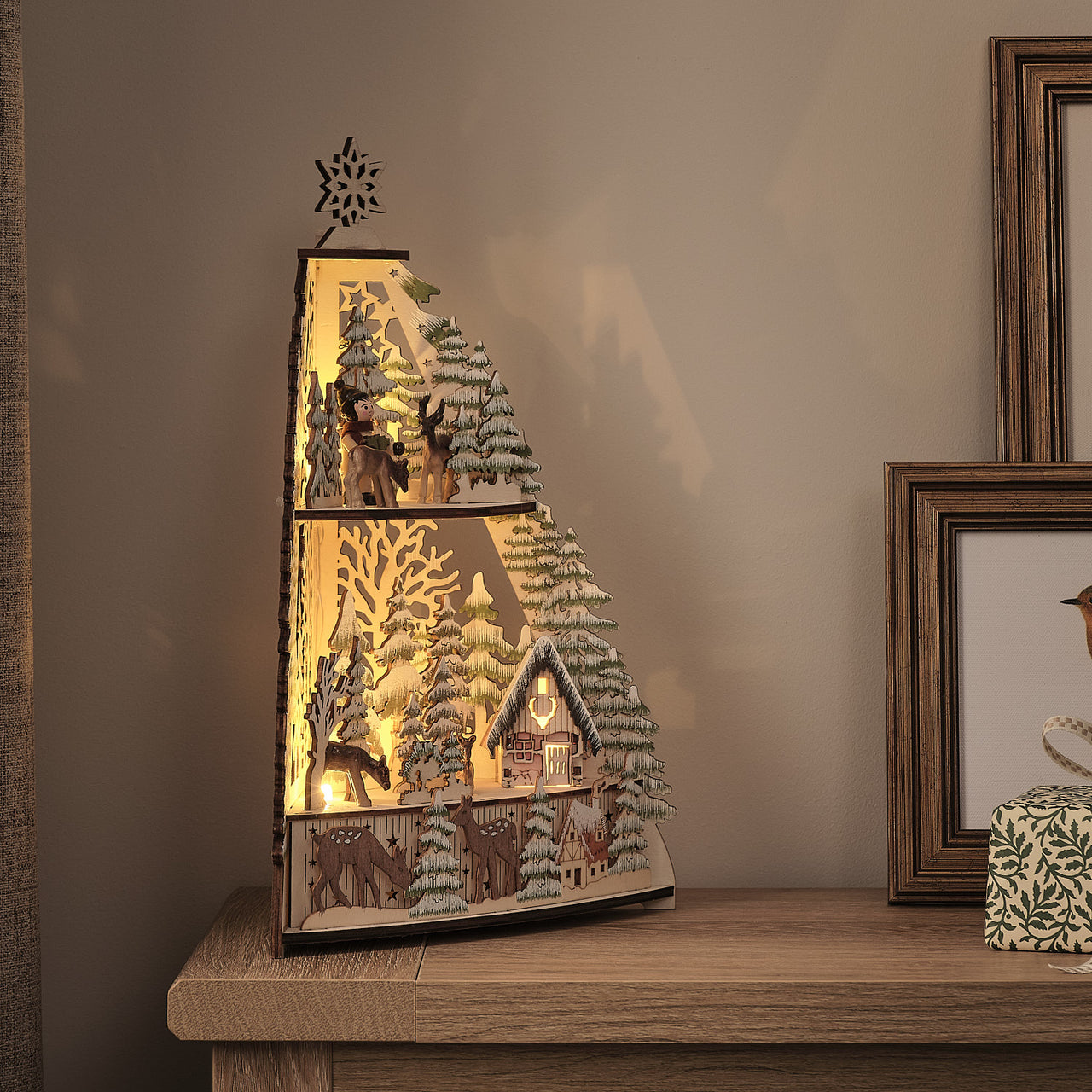 35cm LED-Winterlandschaft aus Holz mit Blockhütte und Timer beleuchtet auf Schrank