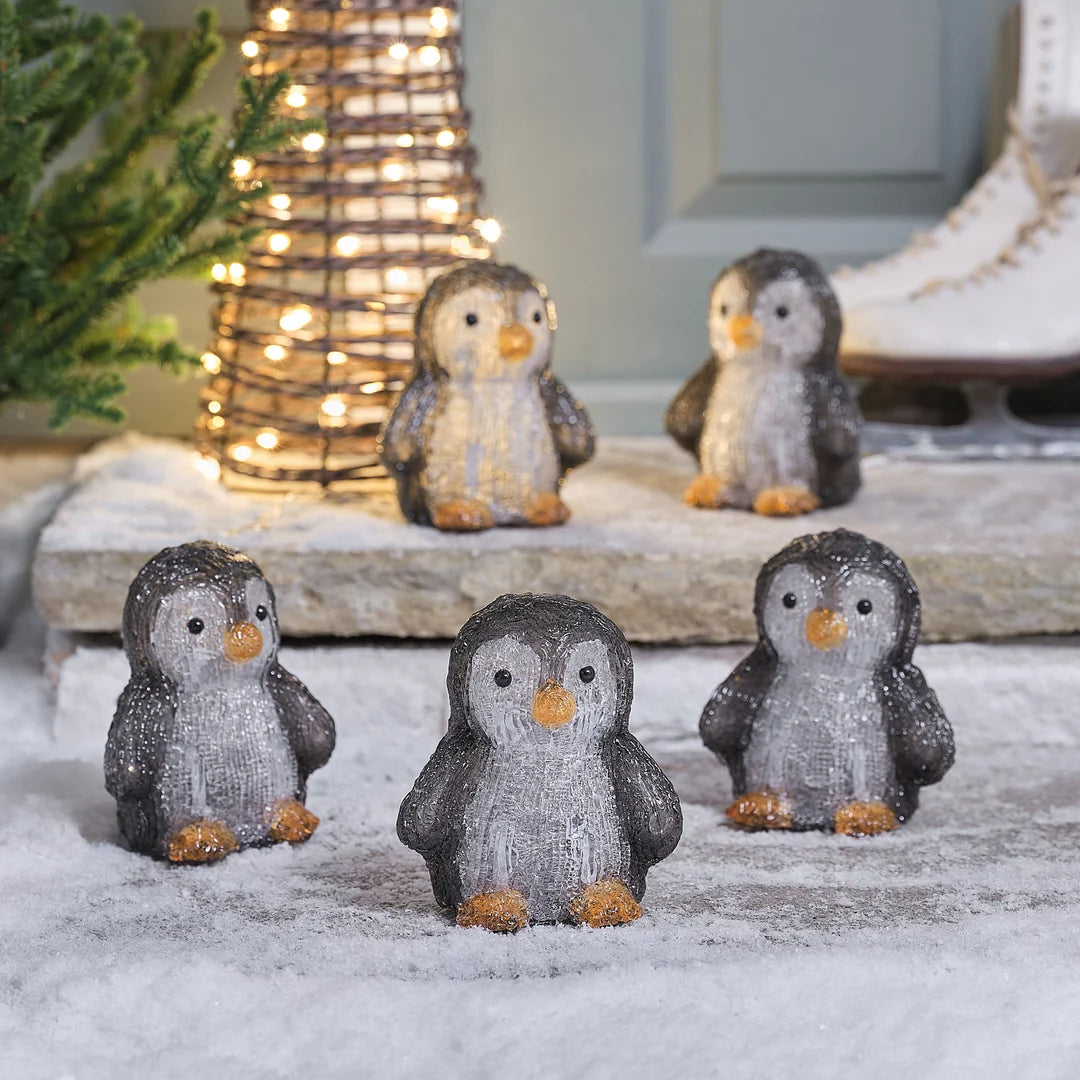 Charmante Familie von grau-glitzernden Pinguin-Dekofiguren mit Schneeeffekt-Textur und goldenen Details, dekorativ auf Steinstufen und Außenbereich arrangiert – niedliche Pinguin-Kollektion für festliche Außendekoration, Hauseingang und winterliche Garten-Displays.