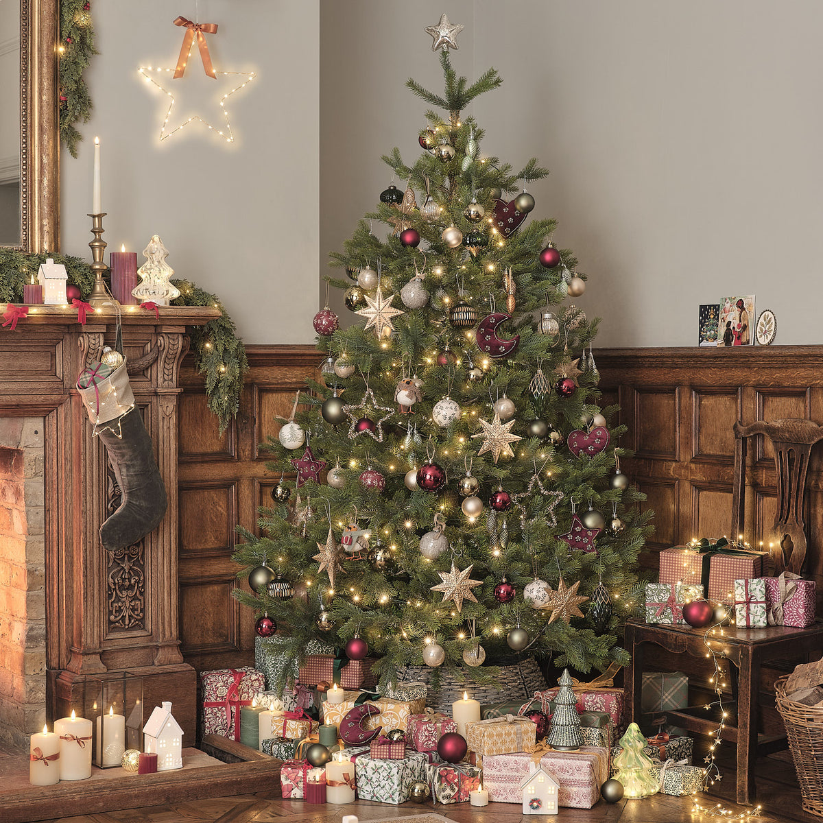 Weihnachtlich geschmückter Baum im Wohnzimmer mit Kamin und Geschenken.