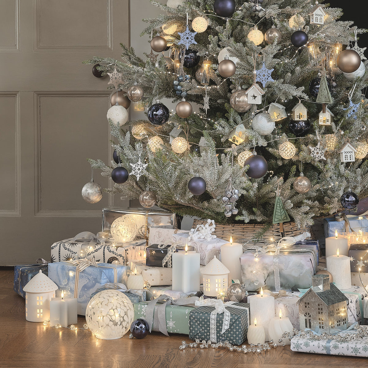 Weihnachtlich dekoriertes Wohnzimmer mit blau-weißem Baum und Geschenken.