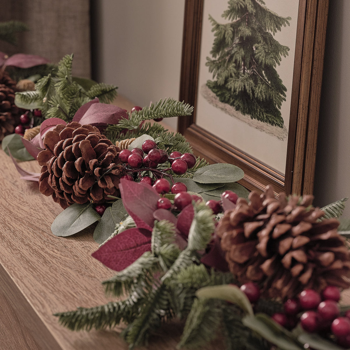 Detailaufnahme der Weihnachtsgirlande mit Tannenzapfen, roten Beeren und warmweißen LEDs