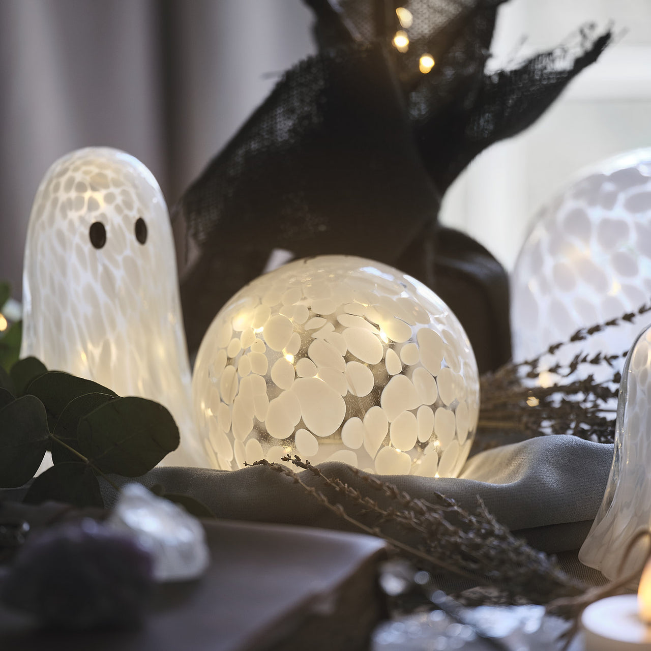 10 cm LED-Glaskugel mit Timer aus Konfettiglas beleuchtet auf Tisch