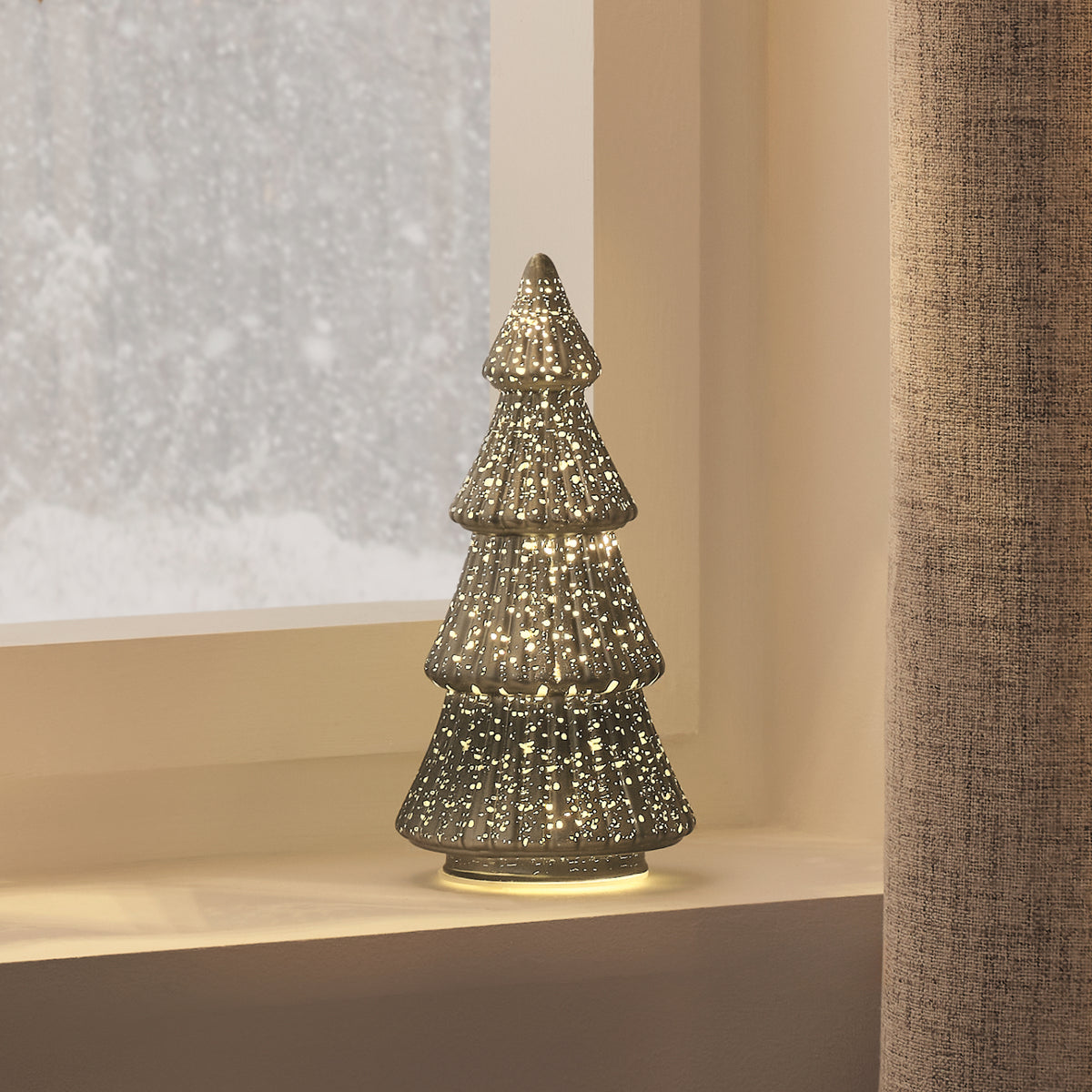 Beleuchteter grüner LED Tannenbaum aus Glas mit goldener Antik-Optik auf Fensterbank