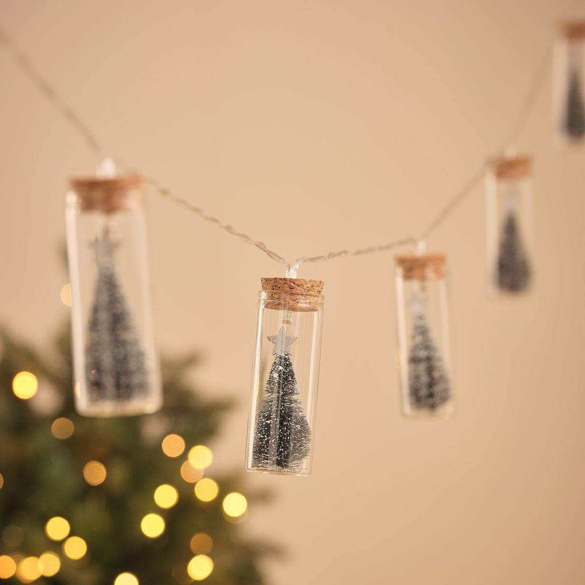 LED-Lichterkette mit Glasflaschen, jede Flasche mit Tannenbaum und goldenem Stern, warmweißes Licht