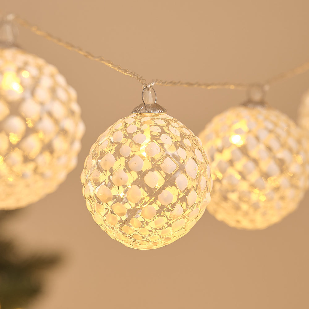 Nahaufnahme einer warmweiß leuchtenden, gefrosteten Glaskugel der LED-Schneeball-Lichterkette