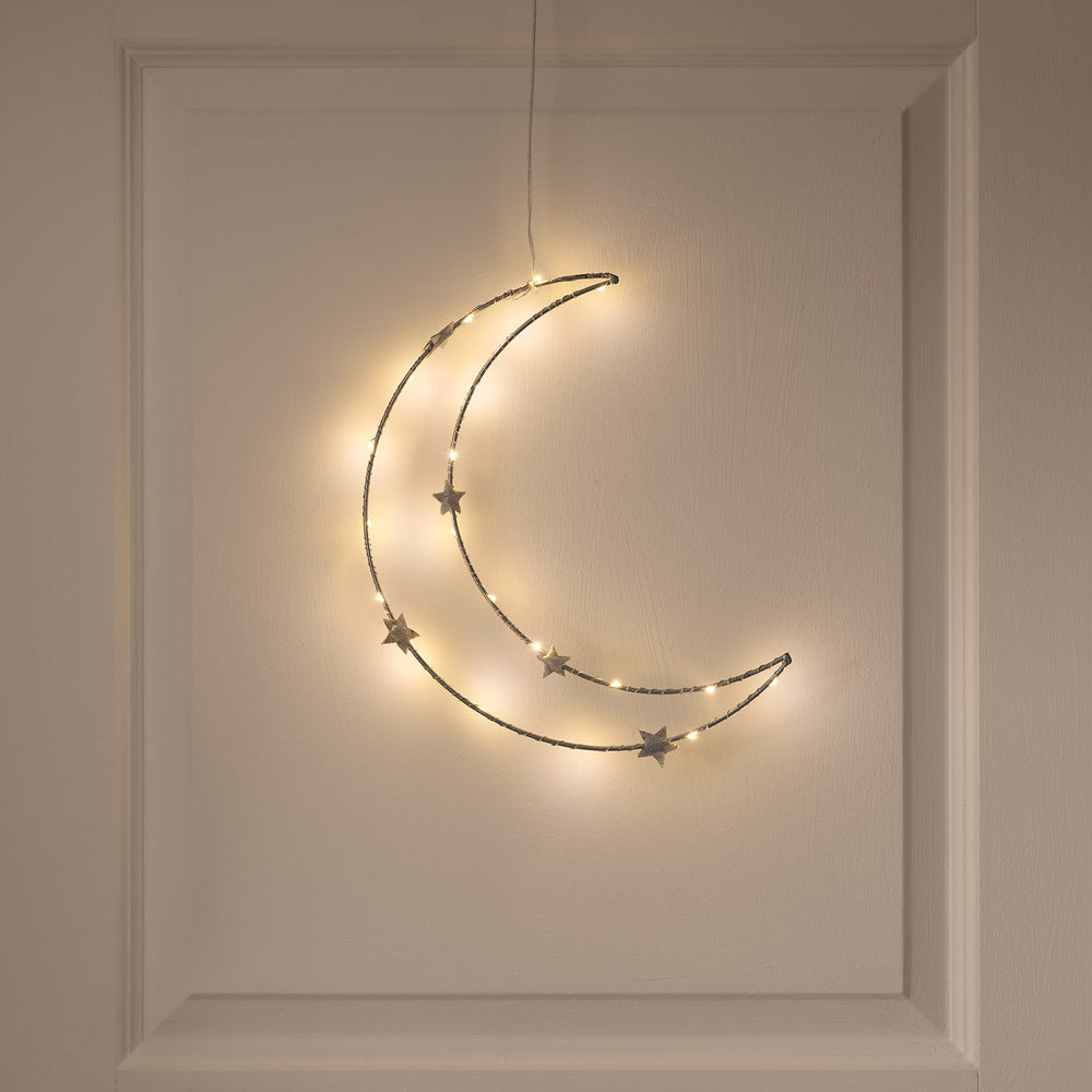 Warmweißer LED-Halbmond mit Sternen zum Aufhängen an weißer Wand