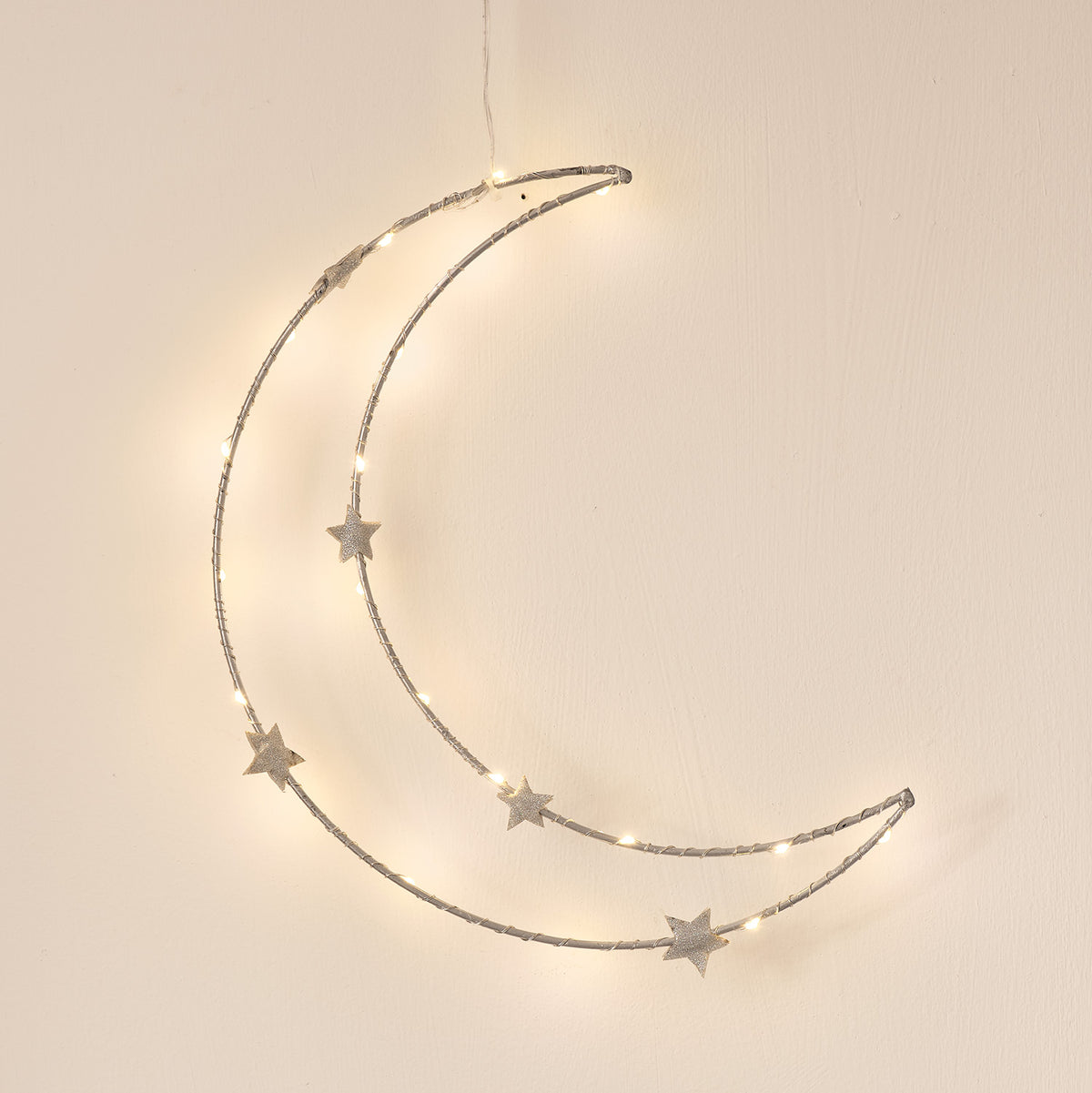 LED-Halbmond mit Sternen an weißer Wand, warmes Licht der Mikro-LEDs sichtbar