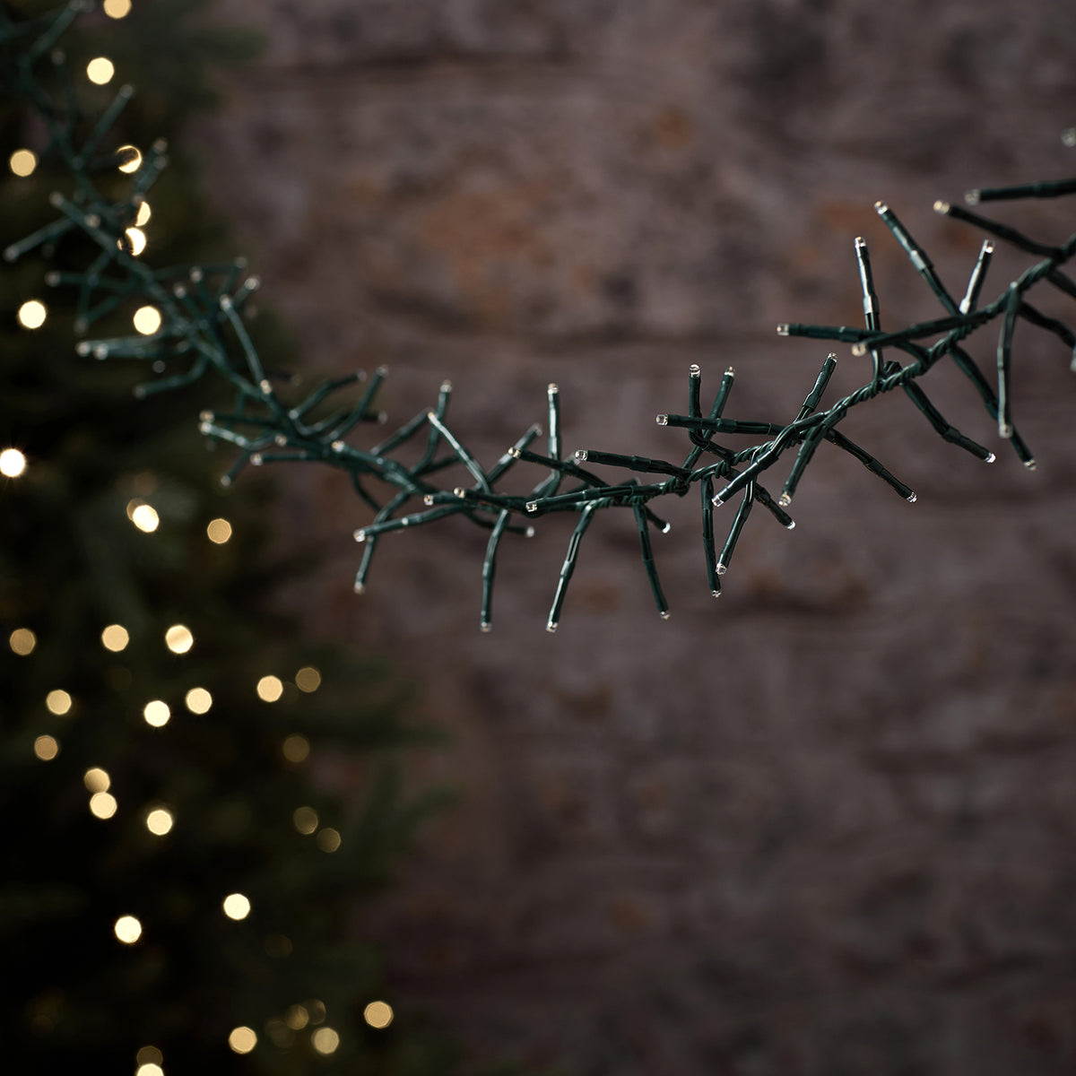 LED-Cluster-Lichterkette mit grünem Kabel und unbeleuchteten LEDs vor unscharfem Hintergrund