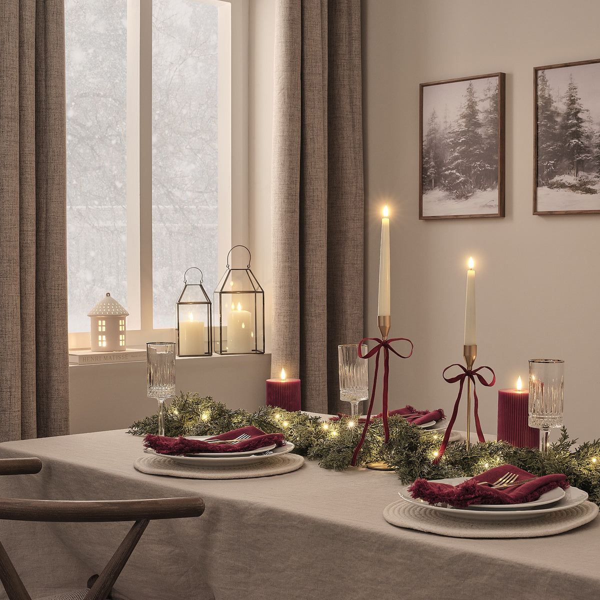 Weihnachtlich gedeckter Tisch mit beleuchteter grüner Girlande, Kerzen und rotem Geschirr in gemütlichem Esszimmer