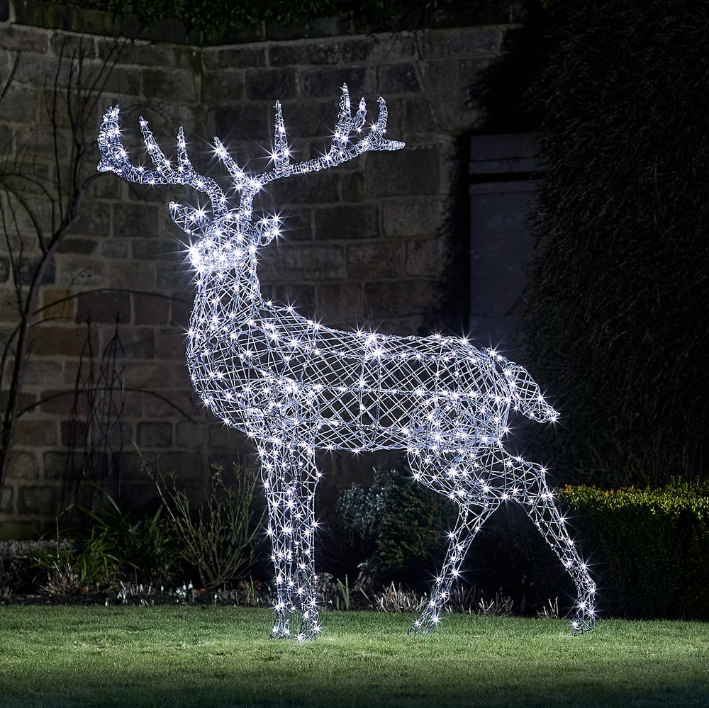 Solar-LED-Rentier in grauer Rattan-Optik mit weiß leuchtenden LEDs im Garten bei Nacht