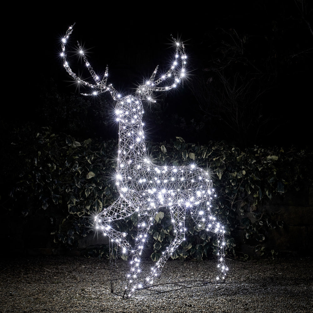 Großer Rentier-Dekohirsch mit weißen LEDs in Rattan-Optik bei Nacht