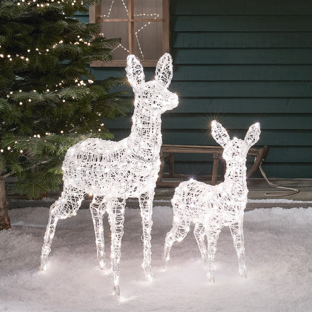 LED-Rentiere Hirschkuh und Rehkitz mit warmweißen und weißen Lichtern auf Schnee vor Hauswand