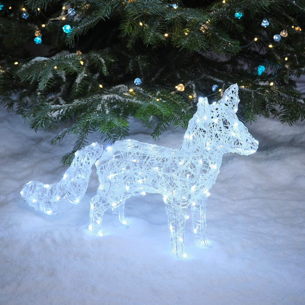 Solar-LED-Polarfuchs Baffin mit weißen LEDs im Schnee vor Tannenzweigen