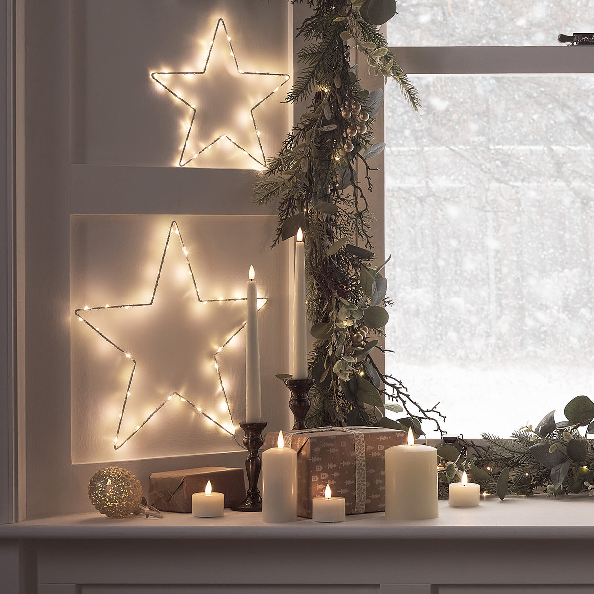 Leuchtender LED-Stern auf weichem Kissen mit Geschenk und Weihnachtsdeko