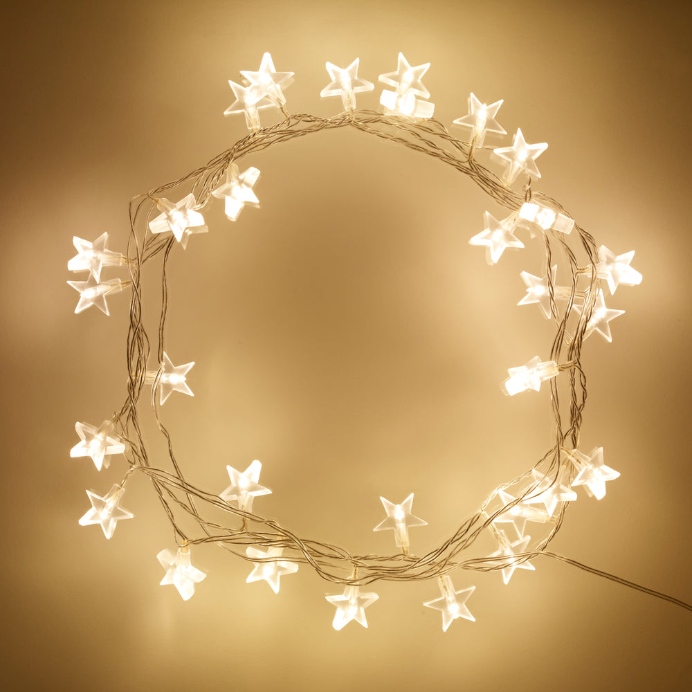 Warmweiße LED Lichterkette mit transparenten Sternen auf beige Hintergrund